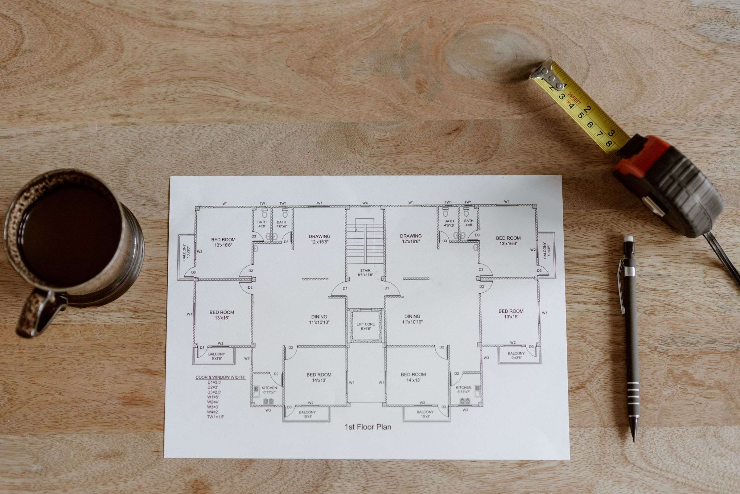 Mètre ruban déroulé sur le parquet d’un logement
